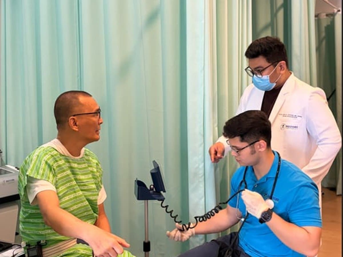 Therapist supporting an older patient walking with a cane