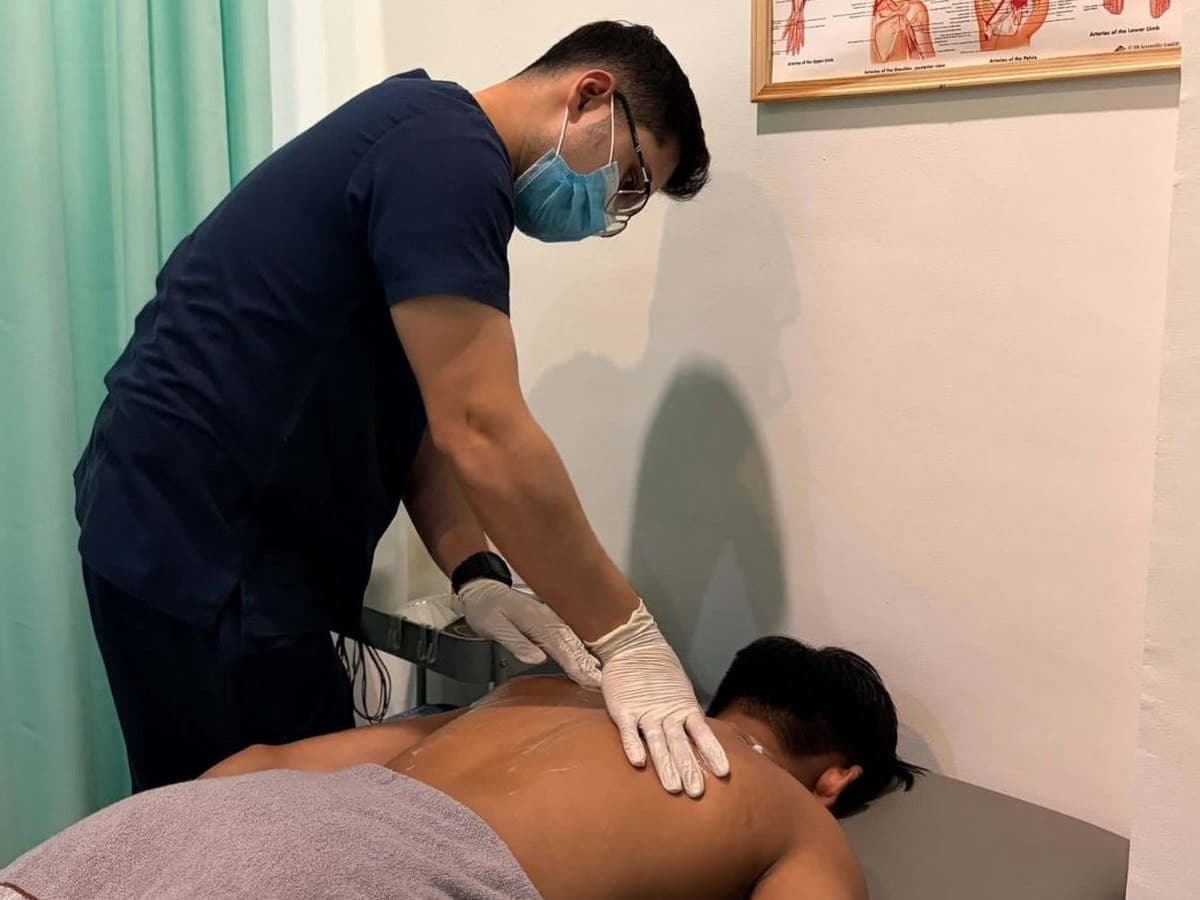 Physical therapist performing hands-on manual therapy on a patient's back