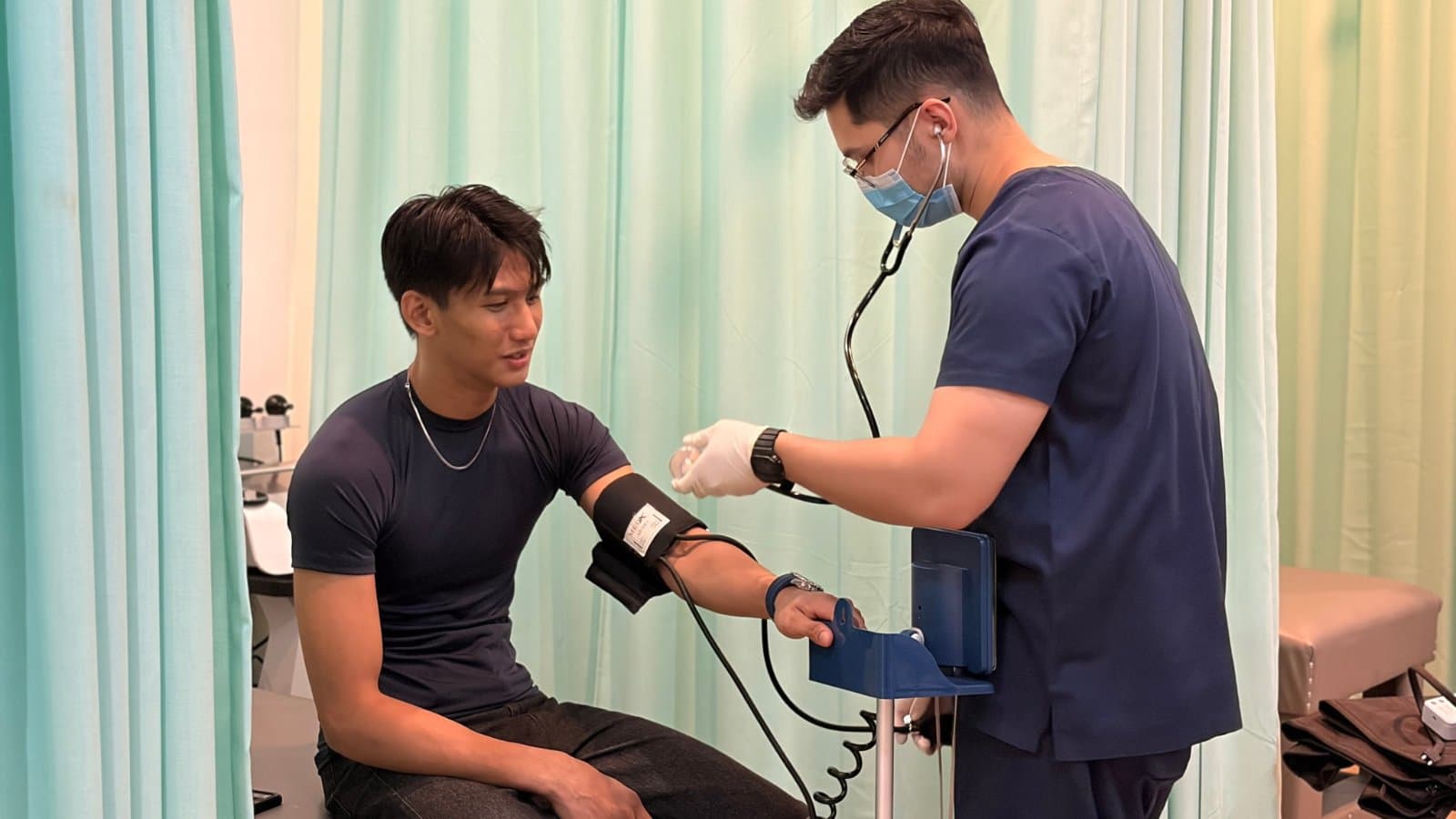 Therapist taking a young athlete's blood pressure before a rehab session